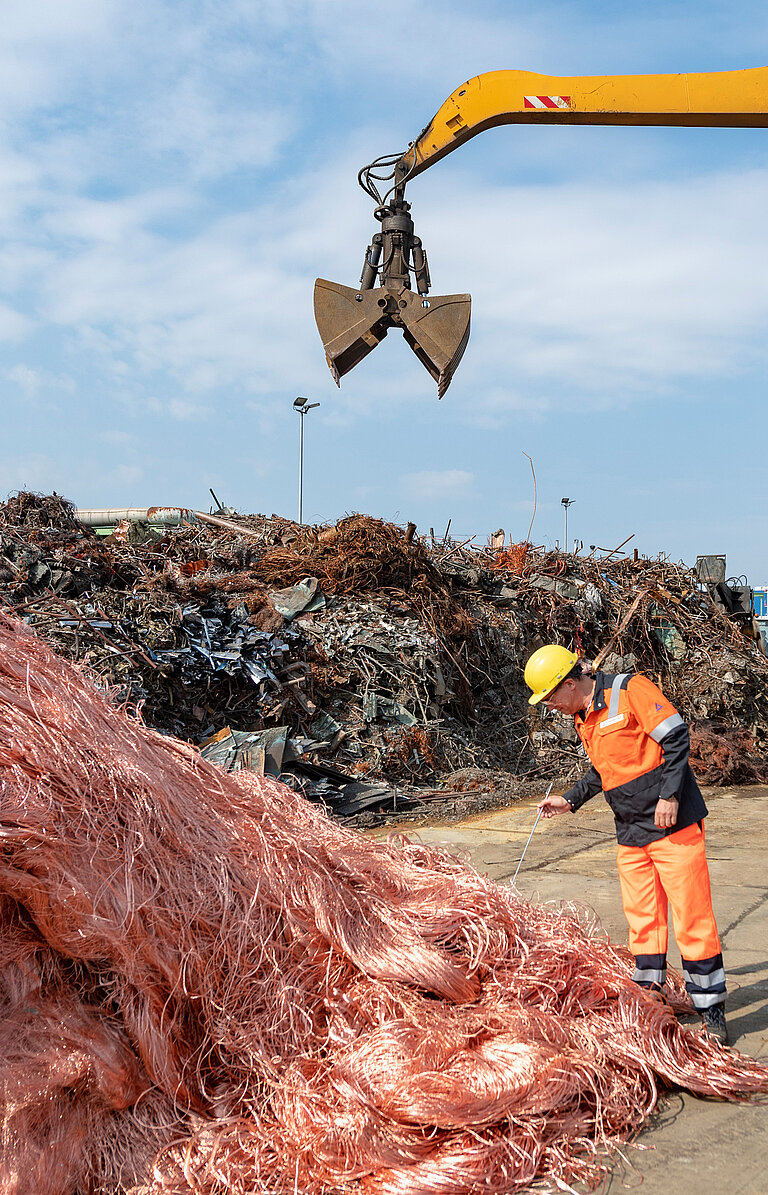 Foto: Aurubis: Bagger neben einem Kupferhaufen